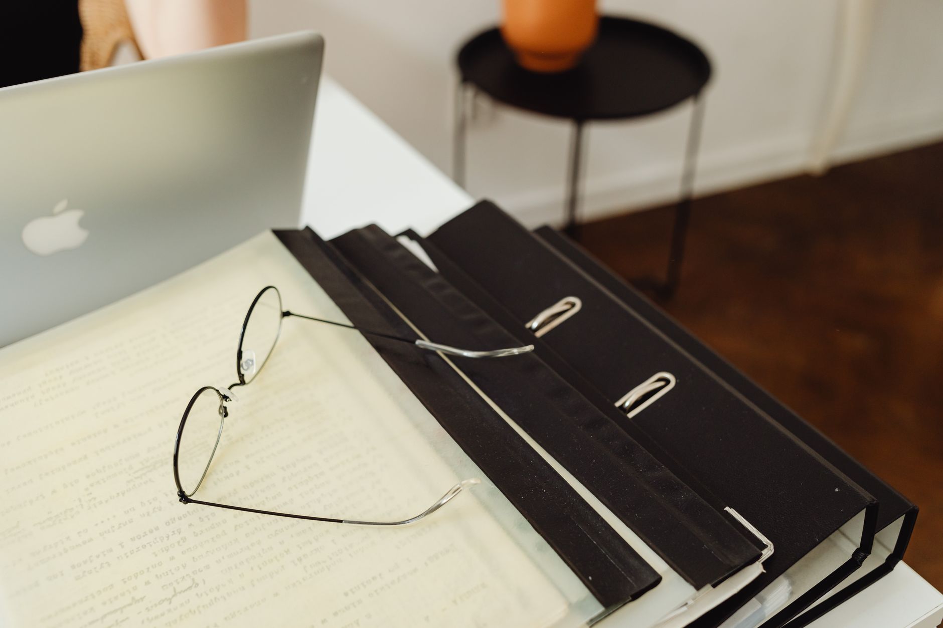 Bureau avec classeurs, une paire de lunettes et un ordinateur portable